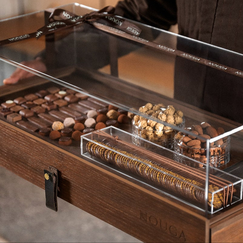 Wooden luxury chocolate display case with various chocolates gifted by person