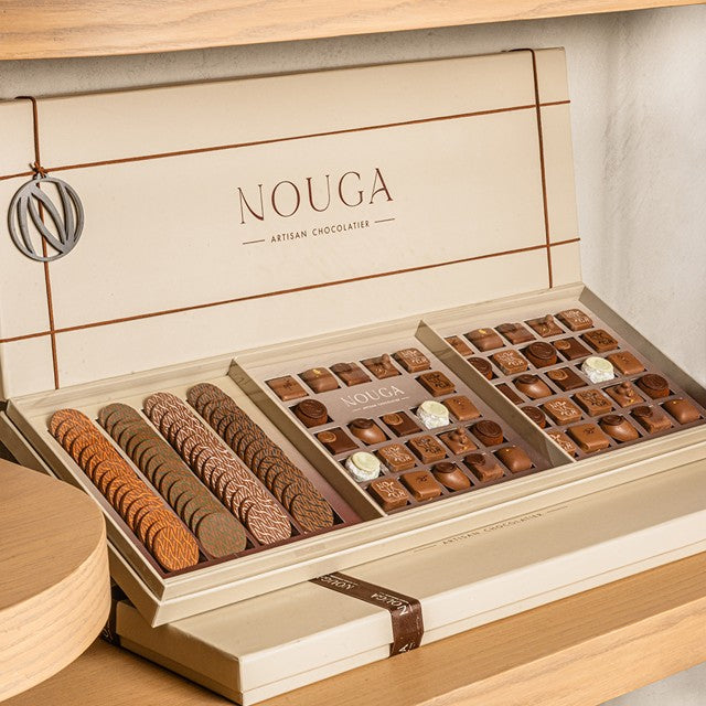 Open box of Nouga chocolates on a wooden surface