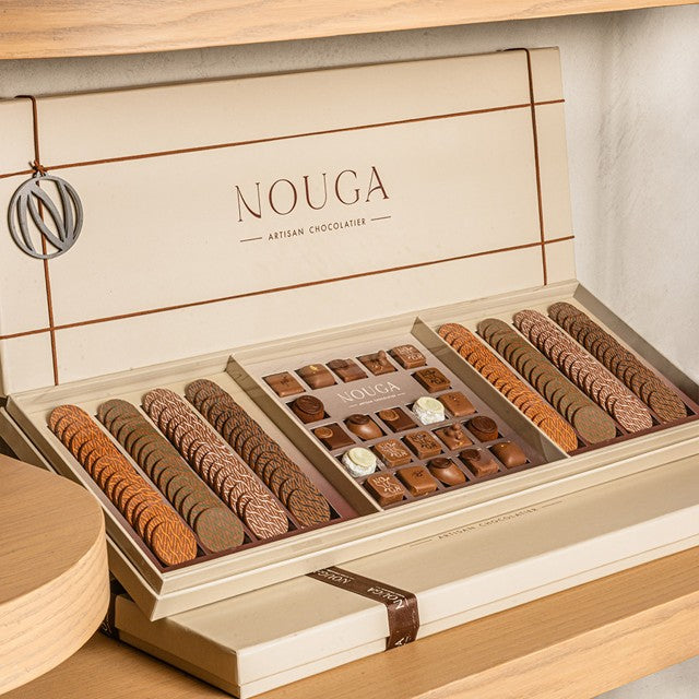 Open box of Nouga chocolates on a wooden surface