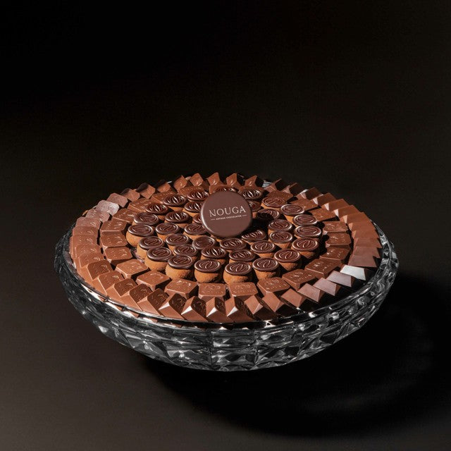 Chocolate assortment in a decorative glass bowl on a dark background