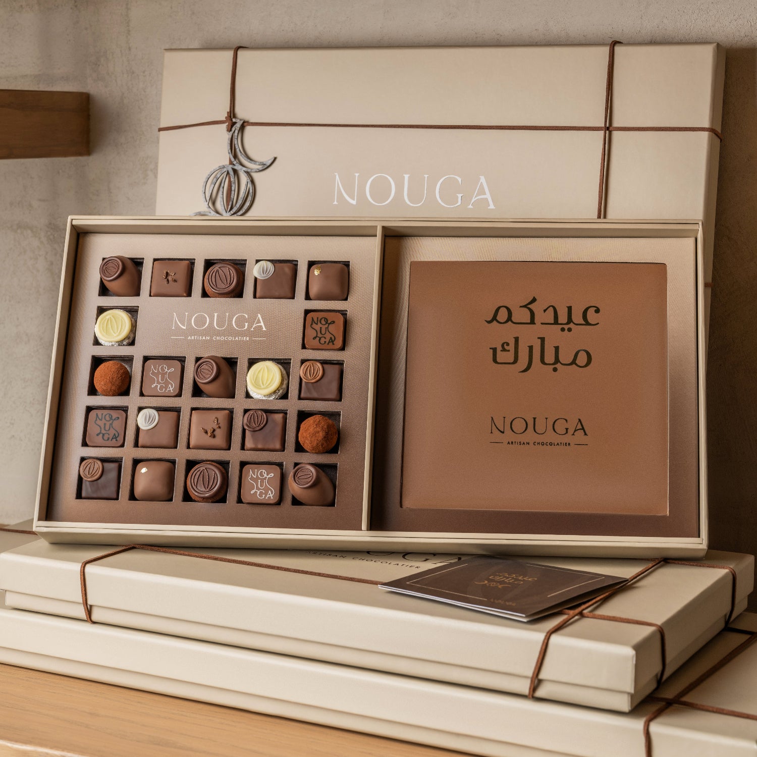 Nouga chocolate box with various flavors on a wooden shelf. Customized chocolate slab message