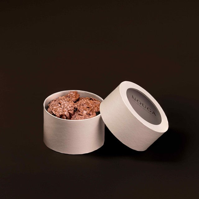 Open container of nouga chocolates on a dark background