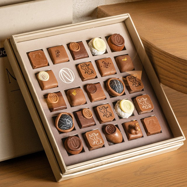 Assorted chocolates in a decorative box on a wooden surface