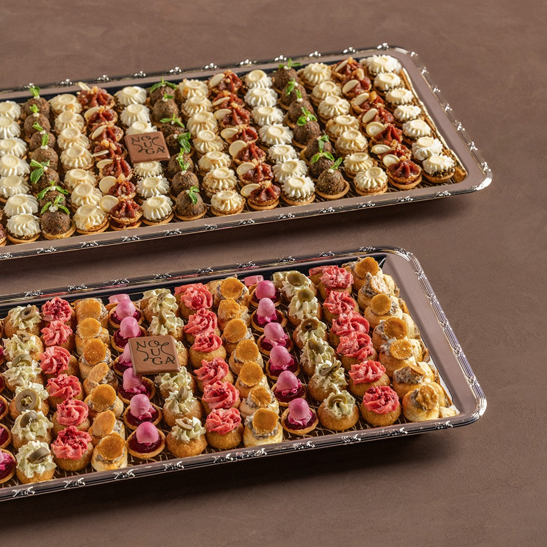 Two trays of colorful mini canapes on a brown background