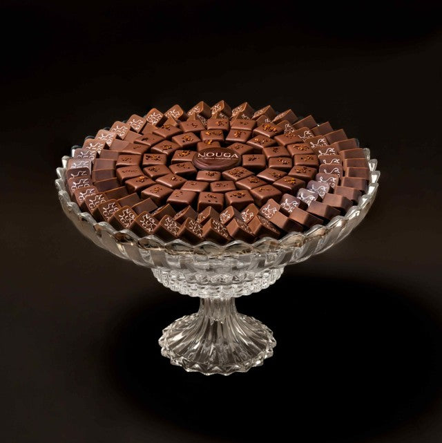 Decorative glass tray with chocolate bonbons on a dark background